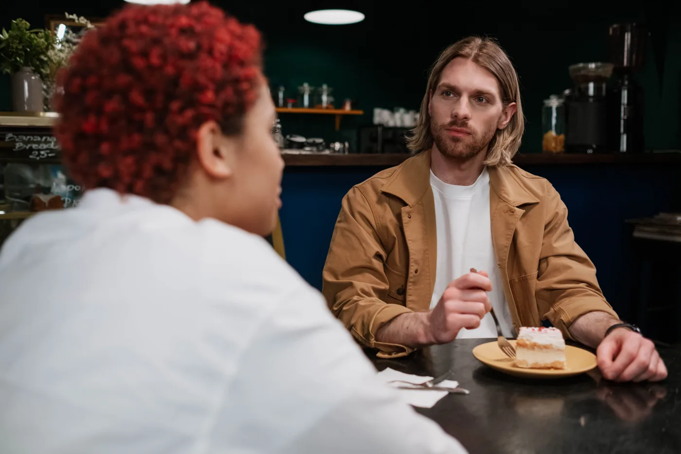 Twee volwassenen bespreken hun verwachtingen tijdens een ontmoeting in een café